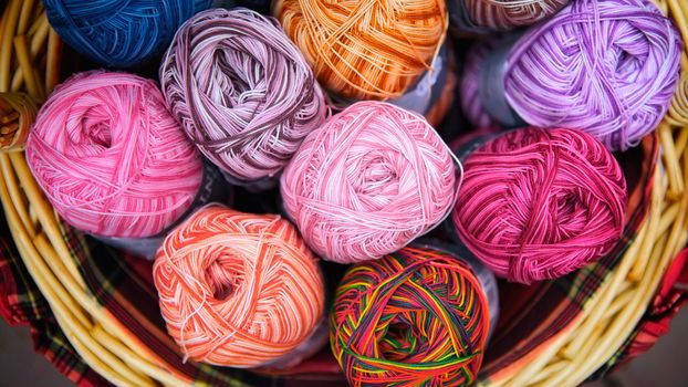 balls of knitted wool in basket, closeup