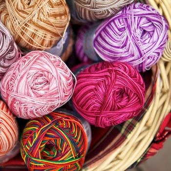 balls of knitted wool in basket, closeup