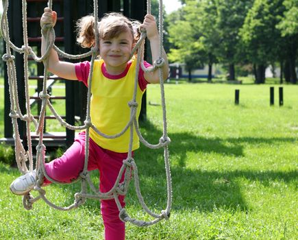 happy little girl playing on playground