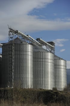 A row of shiny, steel silos