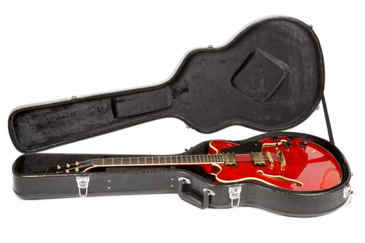 red electric semi-hollow guitar in hard case, isolated on white