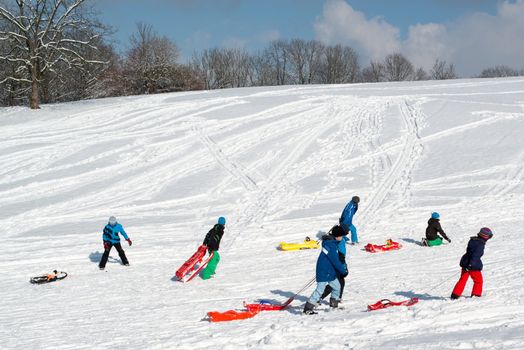Stuttgart, Germany – February 9, 2013: Boys having fun with their sledges, bright and white winter scene on February 9, 2013 on the hills of Feuerbacher Heide in Stuttgart, Germany.