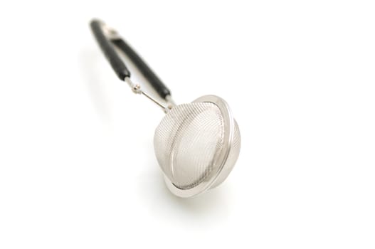 close up of tea strainer on white background