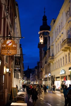 Heidelberg, Germany - February 2, 2013: Tourists walking through the centre of Heidelberg, Germany with its beautiful medieval houses in the evening of February 2, 2013. Heidelberg is a well-known tourist attraction due to its old history and beautiful location at the Neckar river.