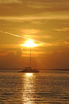 Sailboat in the Atlantic Ocean with a sunset off the coast of the Bahamas