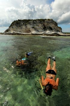 One man and one woman snorkeling in the Bahamas on vacation