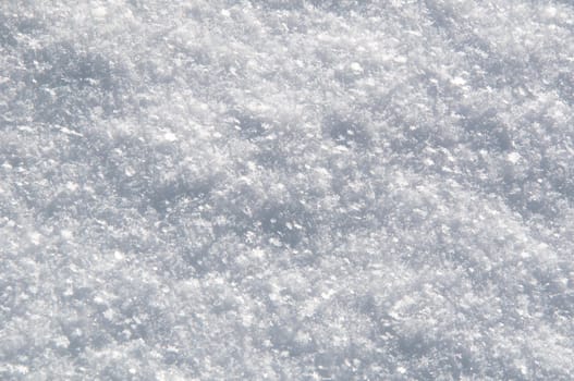 texture of white snow sparkling in the sun on a bright winter day