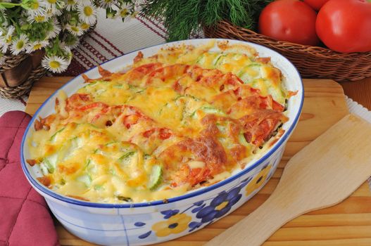 casserole of pasta with zucchini and tomato and cheese on the table