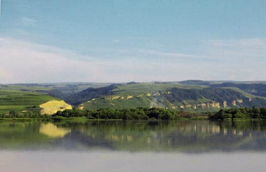 Calm lake and low mountains behind it