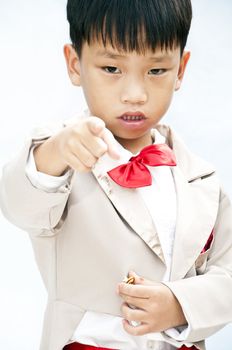 Little boy with brown tuxedo and red bow tie on white background