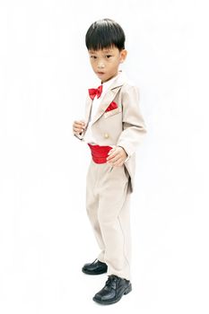 Little boy with brown tuxedo and red bow tie on white background