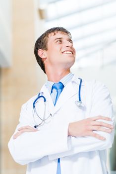 Portrait of a doctor standing in the office and crossed his arms