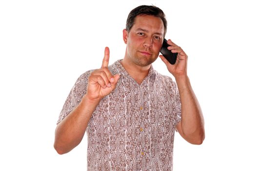 A young man gesturing wait a minute while he is on an important phone call