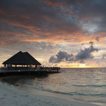 Beach and tropical resort hotel of Maldives on sunset