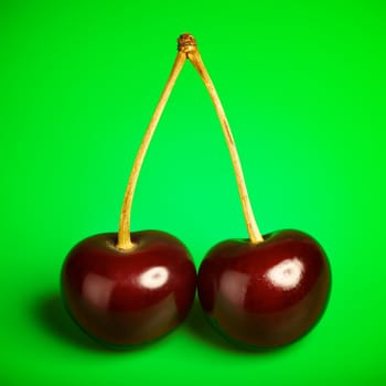 fresh red cherries with stem on green background