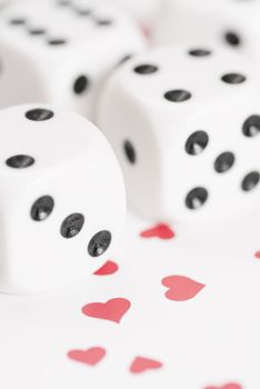 Macro image of dice on love heart background.