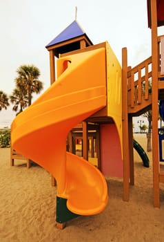 Yellow slide at park during the summertime