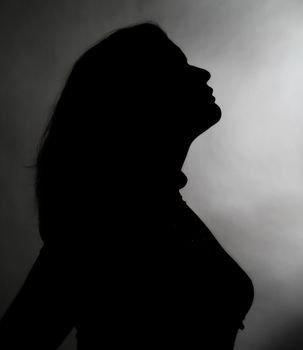 silhouette of a woman in profile on a gray background
