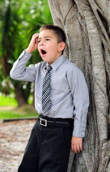 Young boy who is bored dressed in suit