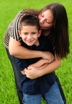 pretty mommy kissing her cute son on the cheek