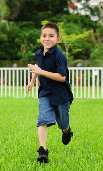 
Happy young Child running on grass and smiling