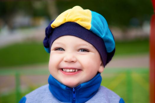 beautiful smiling boy in cap, outdoor portrait