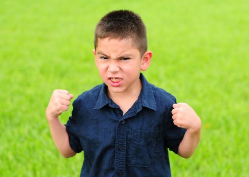 Young boy who is angry with his fists raised