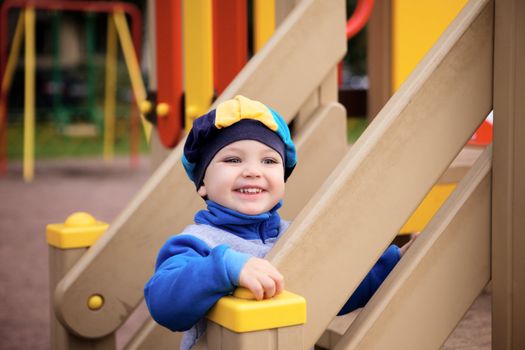 little boy playing on toy hill at playground