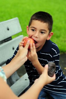 Young boy choosing healthy food over junk food