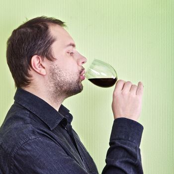 young man drink wine and relax at kitchen