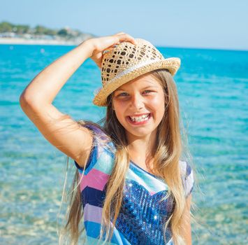 Cute girl in hat on the beach