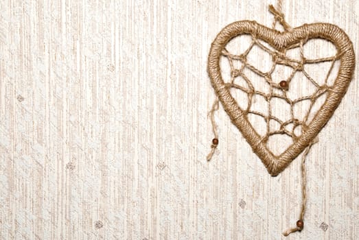 Rope heart on textured background with copy space.