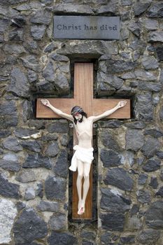 crusifix of jesus on wood cross embedded in rocks