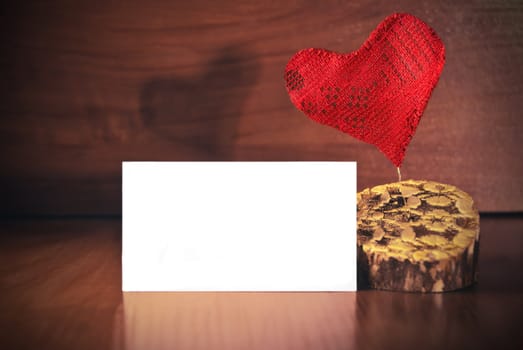 Red heart with card on wood background. Love greeting card