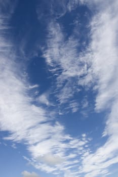 white fluffy clouds and trails against lovely blue sky