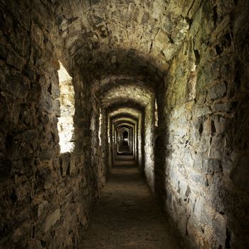 long stone corridor with windows in ancient castle