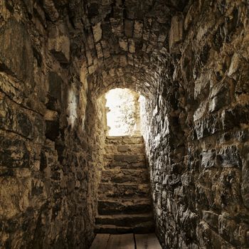 long stone corridor with stairway in ancient castle