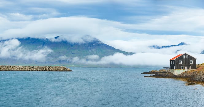 Rural beautiful summer landscape - fjord, house, mountains. Iceland. Panorama.
