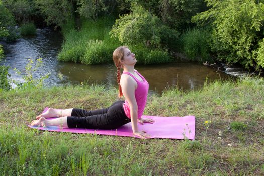 Pretty young woman doing Yoga at sunset.