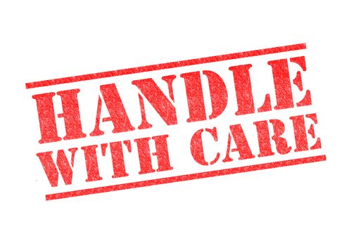 HANDLE WITH CARE rubber stamp over a white background.