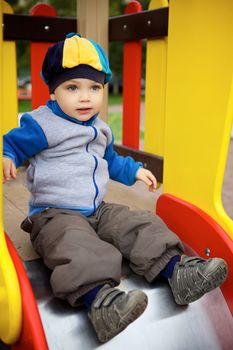 little boy playing on toy hill at playground