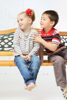 beautiful girl and boy sitting on bench