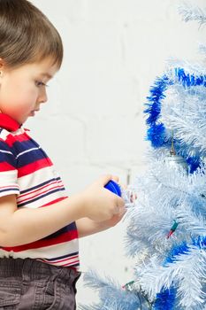 beautiful happy small kid decorate christmas tree