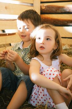 beautiful children on hayloft at sunny day