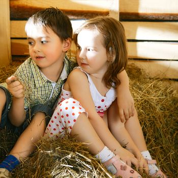 beautiful children on hayloft at sunny day
