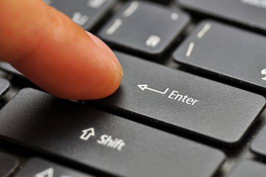 Finger on computer keyboard at enter key