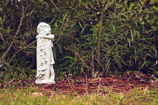 statue of a little kid in the garden 