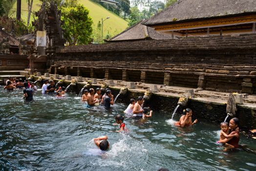 TIRTA EMPUL, INDONESIA - SEP 21: Bali prayers take a bath  in the sacred holy spring water on Sep 21, 2012 in Tirta Empul, Bali, Indonesia. It is famous place for purification of Bali people