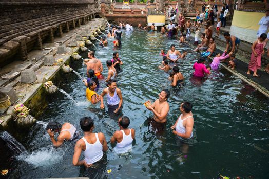 TIRTA EMPUL, INDONESIA - SEP 21: Bali prayers take a bath  in the sacred holy spring water on Sep 21, 2012 in Tirta Empul, Bali, Indonesia. It is famous place for purification of Bali people