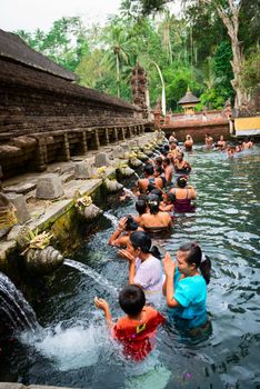 TIRTA EMPUL, INDONESIA - SEP 21: Bali prayers take a bath  in the sacred holy spring water on Sep 21, 2012 in Tirta Empul, Bali, Indonesia. It is famous place for purification of Bali people